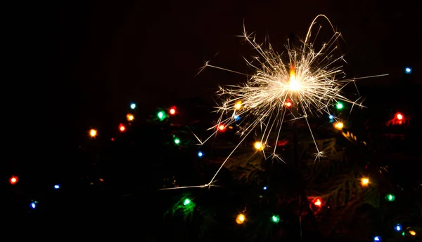 Wunderkerze und Weihnachtsbeleuchtung. — Stockfoto