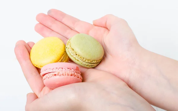 Colorful sweet macaroons in hand — Stock Photo, Image