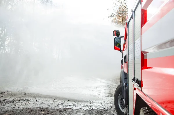 Bomberos con una manguera en acción —  Fotos de Stock