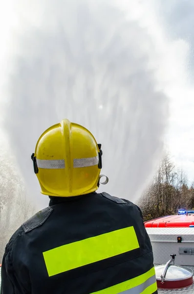 Firefighters with a hose in action — Stock Photo, Image