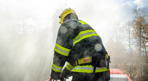 Firefighters with a hose in action — Stock Photo, Image