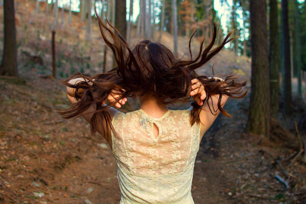 A woman with long hair looking at forest.