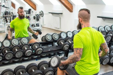 Sakallı adam dumbbells ile.