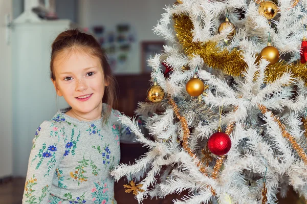 Ritratto ravvicinato di una bambina carina che gioca con i giocattoli di Natale — Foto Stock