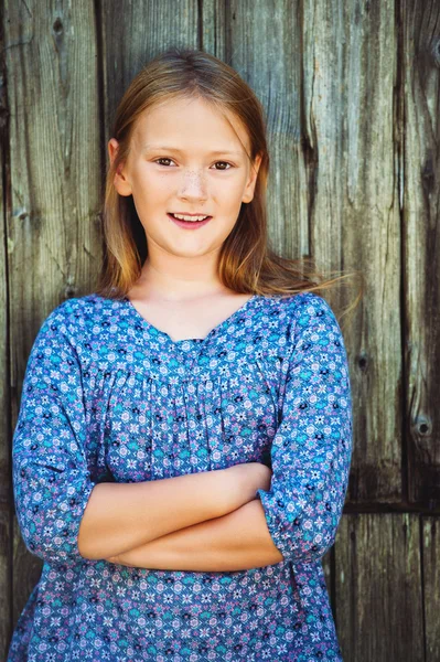 Portræt af en sød lille pige på 8-9 år, iført blå kjole - Stock-foto