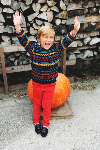 Entzückender kleiner Junge von 5-6 Jahren wählt Halloween-Kürbis auf dem Bauernmarkt — Stockfoto