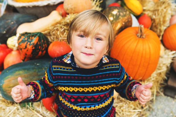 Entzückender kleiner Junge von 5-6 Jahren wählt Halloween-Kürbis auf dem Bauernmarkt — Stockfoto