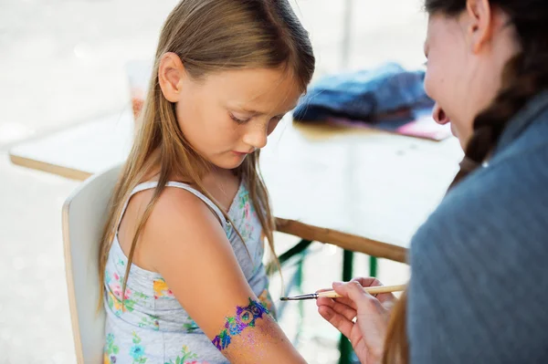 Little girl getting glitter tattoo at birthday party — Stock Photo, Image