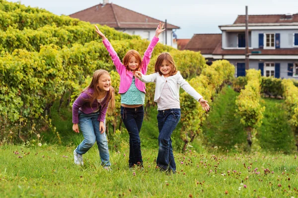 3 bambine che si divertono all'aria aperta, indossando jeans di jeans e t-shirt colorate — Foto Stock