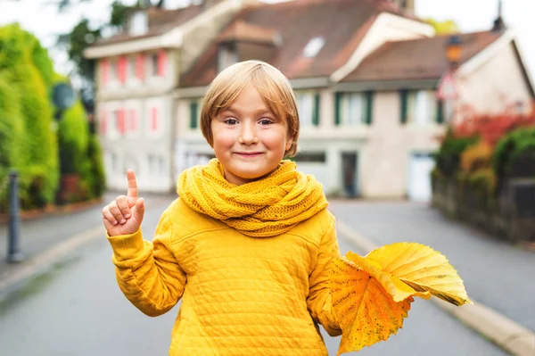 Retrato de moda al aire libre del adorable niño rubio de 5-6 años, con sudadera y bufanda amarilla —  Fotos de Stock