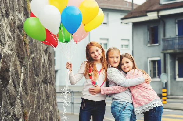 Ritratto all'aperto di 3 bambine carine con palloncini colorati, che indossano felpe — Foto Stock