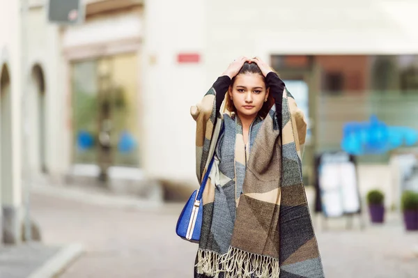 Outdoor fashion portrait of young 20 year old girl wearing grey and beige scarf jacket and blue bag — Stock Photo, Image