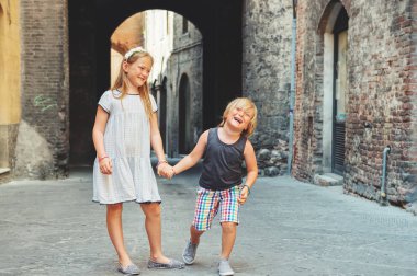 Sienna, İtalya sokaklarında oynayan iki şirin çocuklar. Küçük turistler Avrupa, yaz tatili