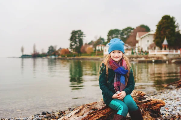 Meisje rusten door meer van Genève in de winter, het dragen van warme muts en sjaal — Stockfoto