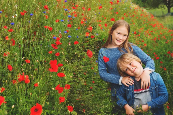 Retrato al aire libre de dos niños lindos jugando en el campo de amapola — Foto de Stock