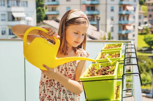 Meisje Bewateren van planten op het balkon — Stockfoto