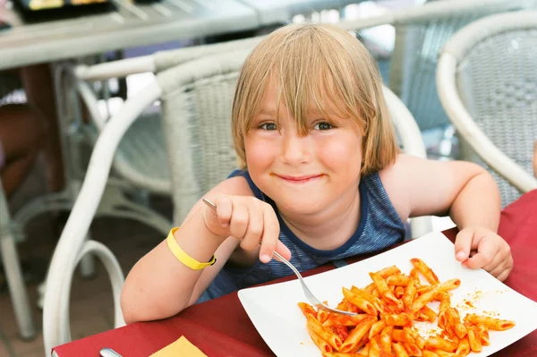Adorable toddler boy eating pasta with tomatoe sause in restaurant — Stock Photo, Image