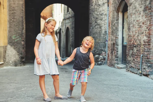 Two cute kids playing on the streets of Sienna, Italy. Little tourists visiting Europe, summer vacation — Stock Photo, Image
