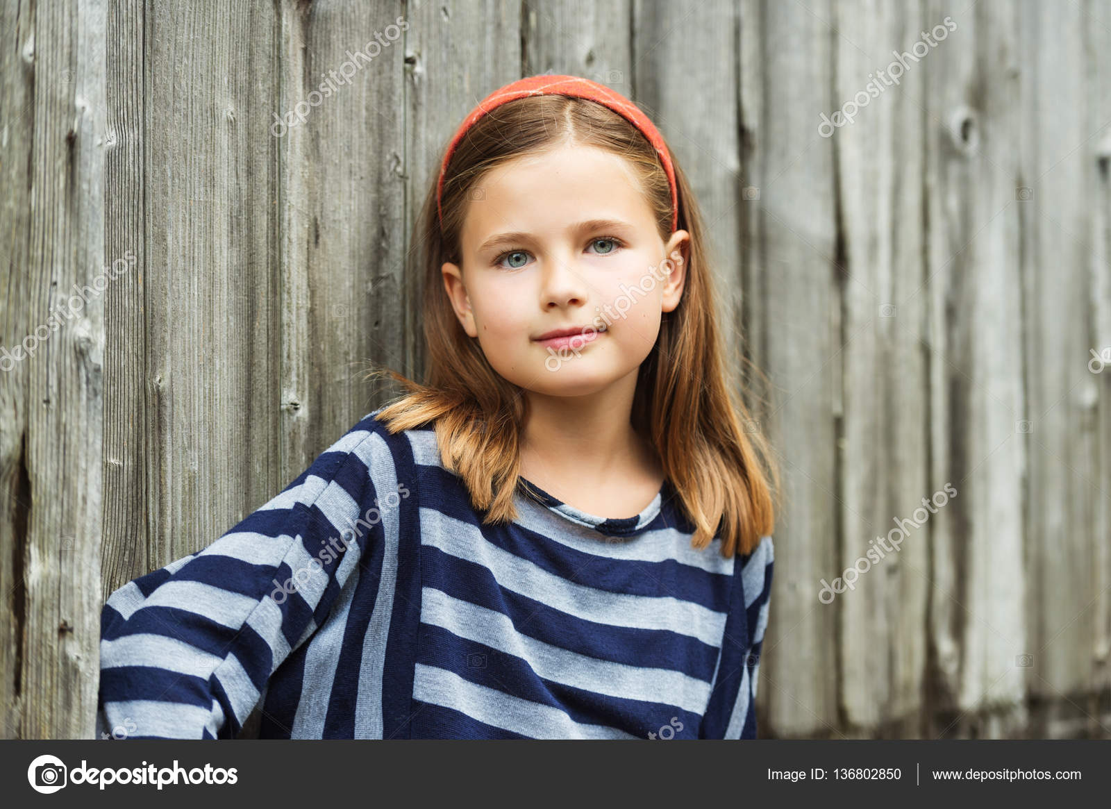 Outdoor portrait of cute little 8-9 year old girl with brown hair