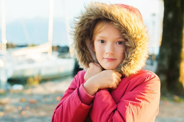 Utomhus närbild porträtt av söt 9-10 år gamla lilla flicka klädd varm vinter jacka med huva och päls — Stockfoto