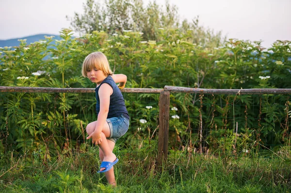 Kleine jongen buiten spelen in platteland op een warme mooie dag — Stockfoto