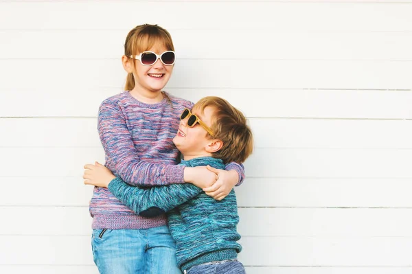 Moda niños al aire libre, con pulóveres de punto y gafas de sol, tomados de la mano — Foto de Stock