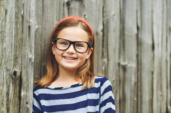Egy aranyos kis 9 év régi lány visel szemüveget szabadtéri portréja — Stock Fotó