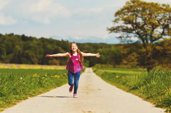 Ragazza che corre lungo la strada in campagna in una giornata molto calda, immagine scattata nel Canton Vaud, Svizzera — Foto Stock