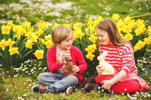 可爱的小的孩子，大姐姐和小弟弟，与巧克力复活节兔子庆祝传统节日。家庭，假期，春天，无忧无虑的童年概念. — 图库照片