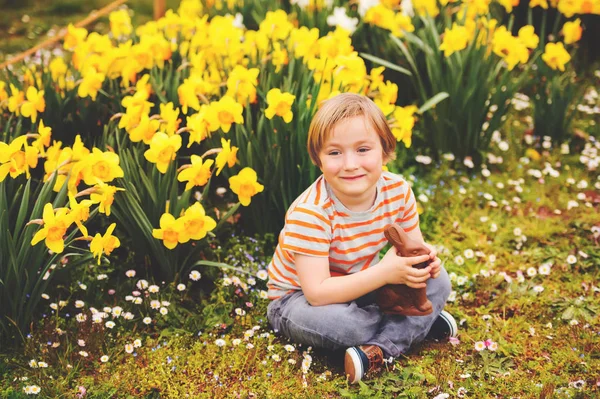 Cute little kid boy with chocolate Easter bunny celebrating traditional feast. Family, holiday, spring , carefree childhood concept. — Stock Photo, Image