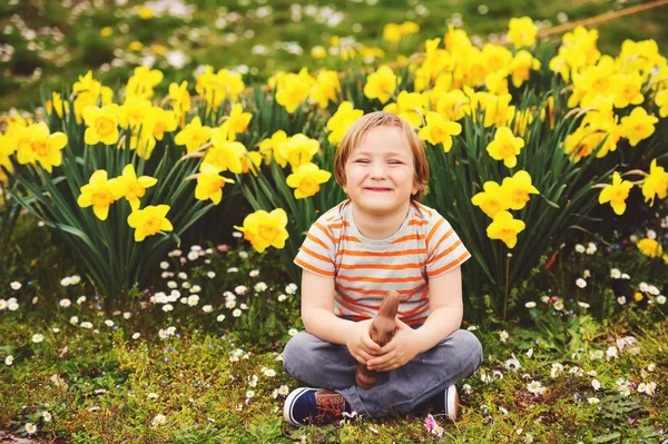 Menino bonito com chocolate coelho da Páscoa celebrando festa tradicional. Família, férias, primavera, conceito de infância despreocupada . — Fotografia de Stock