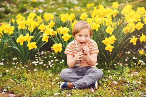 Cute little kid boy with chocolate Easter bunny celebrating traditional feast. Family, holiday, spring , carefree childhood concept. — Stock Photo, Image