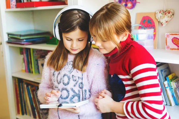 Duas meninas bonitos jogando no computador tablet digital — Fotografia de Stock