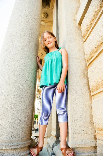 Retrato de verano de una linda niña vistiendo top verde, jugando al aire libre en una ciudad —  Fotos de Stock