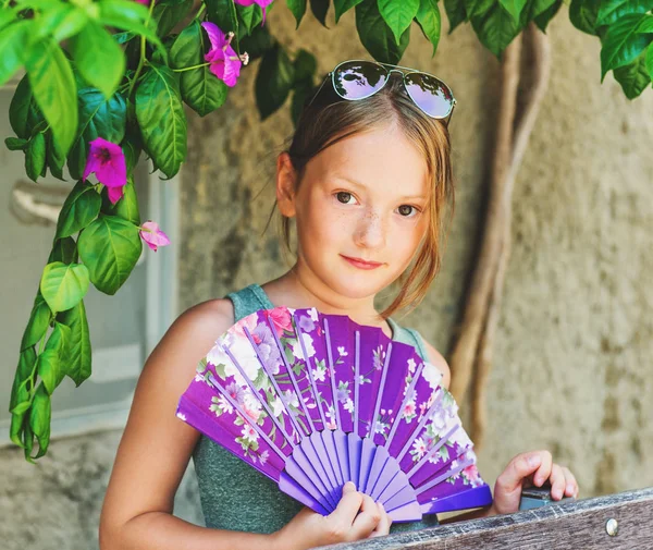 Summer portrait of pretty 7-8 year old girl with purple fan — Stock Photo, Image