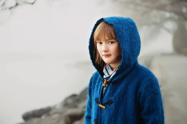 Ritratto all'aperto della bambina di 9-10 anni in una giornata molto nebbiosa, con indosso un cappotto blu scuro con cappuccio — Foto Stock