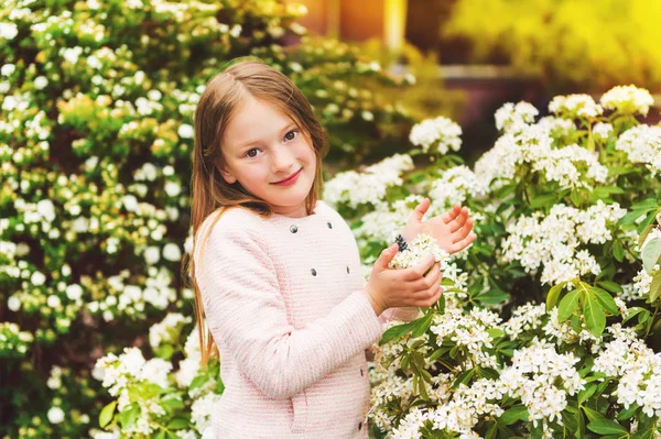 7-8 yıl eski güzel küçük kız pembe ceket ile bahar çiçekleri, açık portresi — Stok fotoğraf