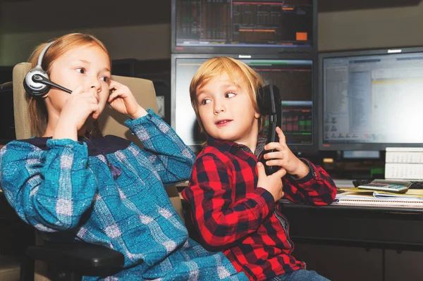 Adorable niño y su hermana pasan el día en el trabajo de sus padres en una sala de comercio en el banco —  Fotos de Stock