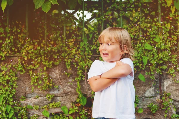 Sommerporträt eines entzückenden Kleinkindes mit weißem T-Shirt und verschränkten Armen — Stockfoto