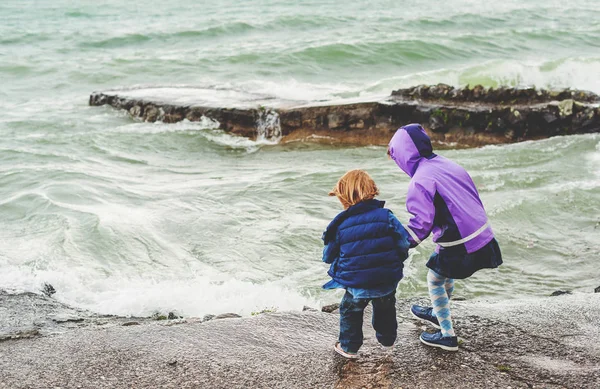 Group of two little kids playing by lake Geneva on a very windy day, Switzerland — Stock Photo, Image