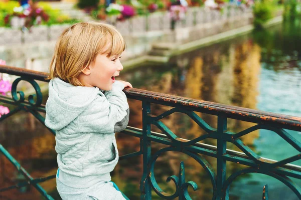 Retrato ao ar livre de um menino loiro bonito olhando para o belo canal em Annecy, França. Viajar com crianças — Fotografia de Stock