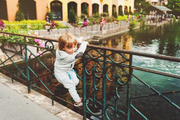 アヌシー, フランスの美しい運河を見てかわいい金髪の男の子の屋外のポートレート。子供と旅行します。 — ストック写真