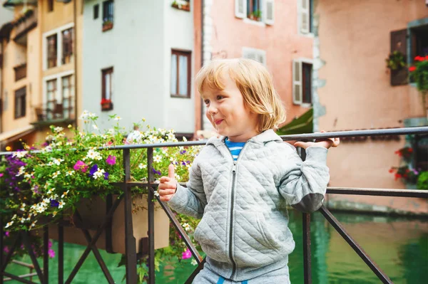 Zewnątrz portret ładny mały chłopiec blond patrząc na pięknym kanale w Annecy, Francja. Podróż z dziećmi — Zdjęcie stockowe