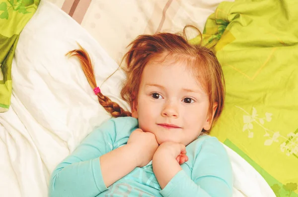Adorable 3 year old girl lying on a bed, top view — Stock Photo, Image
