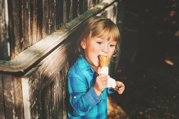 Adorável menino loiro de 3 anos comendo sorvete ao ar livre — Fotografia de Stock