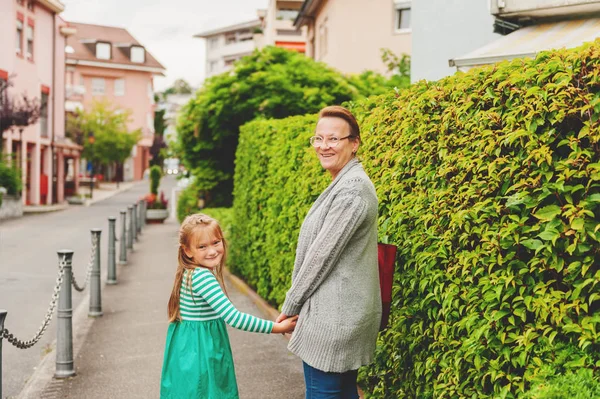 Babička a malá holčička, procházky venku, drželi se za ruce — Stock fotografie