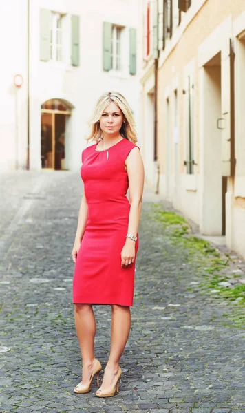Portrait extérieur de jeune femme blonde portant une robe rouge — Photo