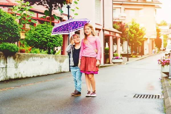 Entzückende Kinder haben Spaß im Freien, spielen unter dem Regen — Stockfoto