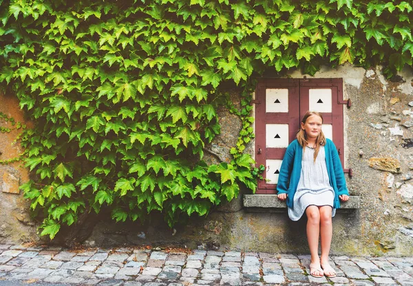 Utomhus mode porträtt av en söt liten flicka mot ivy vägg — Stockfoto