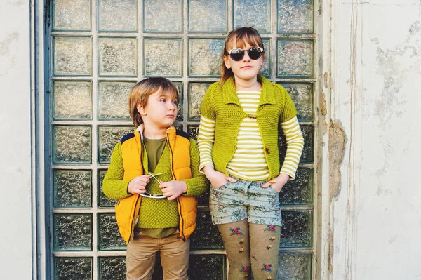 Duas crianças felizes brincando ao ar livre, menino de moda e menina posando na rua — Fotografia de Stock